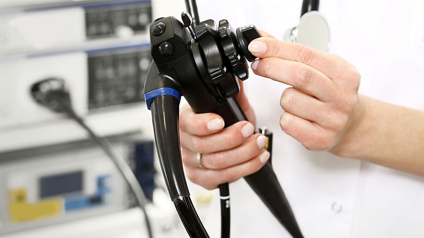 A doctor turning the dial of the flexible endoscope they are holding